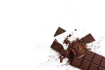 Broken organic dark chocolate bar and chocolate powder on isolated white background from above