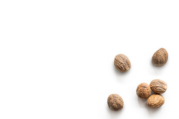 Closeup organic whole raw nutmegs on isolated white background from above