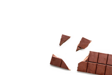 Broken organic milk chocolate bar on isolated white background from above