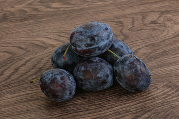 Ripe plum heap over background