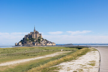 Vue sur le Mont Saint-Michel devant un p&acirc;turage des pr&eacute;s sal&eacute;s et ses agneaux