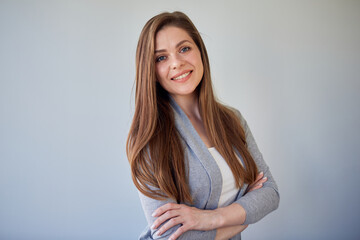 Fototapeta premium Beautiful smiling woman with natural skin and long hair. Isolated portrait of girl wearing casual clothes on gray background.