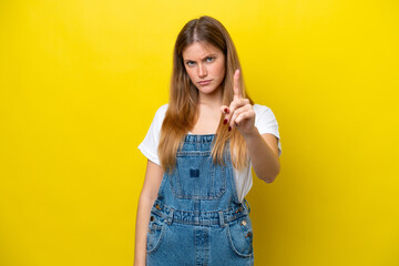 Young caucasian woman isolated on yellow background frustrated and pointing to the front