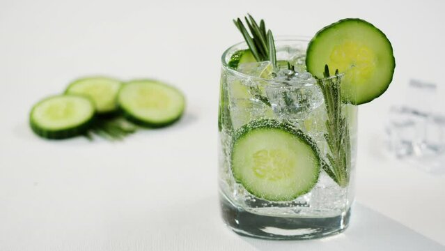 Cucumber and rosemary lemonade. Gin tonic cocktail close-up, healthy drink on white background. Detox drinking, summer refreshment concept.