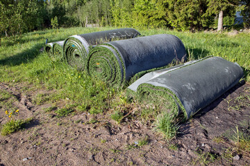 Rolls of old artificial grass outdoors