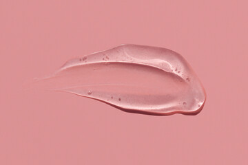 Gel texture smear stroke on pink background, skin care product snail mucin or moisturiser serum swatch