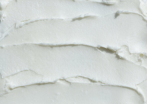 Raw shea butter texture smudged smear background, thick buttery cream hair and skin care product