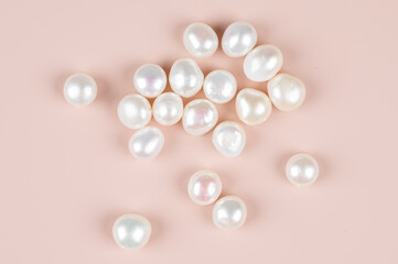 Natural freshwater round pearl beads on pink background. Top view