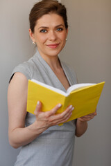 Teacher woman holding open book, or student girl with work book.