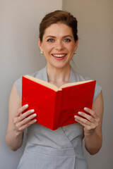 Happy woman teacher holding red open book. Teacher profession portrait.