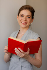 Obraz premium Happy woman teacher holding red open book. Teacher profession portrait.