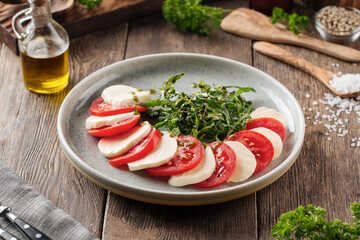 Portion of fresh caprese salad on wooden background