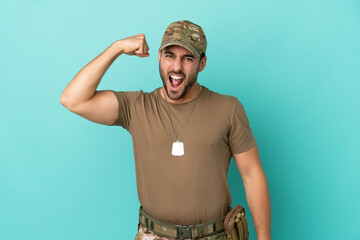 Military with dog tag over isolated on blue background doing strong gesture