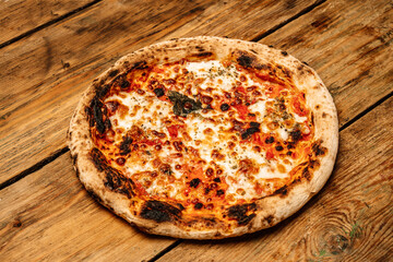 Pizza food background. Homemade Neapolitan pizza Margherita with mozzarella cheese and tomato sauce on a rustic wooden table. Italian food.