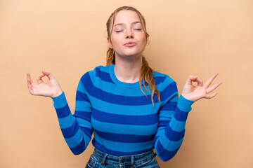 Young caucasian woman isolated on beige background in zen pose