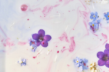 Wildflowers in milky water with paint streaks. Purple and blue. Abstraction, background image....