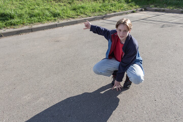 Fototapeta premium A teenager, a young man passionate about modern dancing dances alone on the street, in the fresh air.