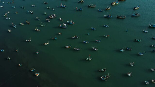 Aerial, fishing boats in Vietnam, Southeast Asia moored on ocean harbor bay. Overfishing concept