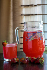 Fresh strawberry juice in a glass by the window.