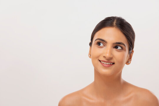 Close-up portrait of a cheerful young woman with clear and spotless skin