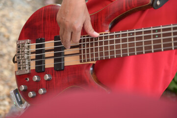 man playing red guitar close up