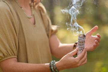 occult science and supernatural concept - close up of woman or witch with smoking white sage...