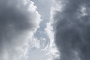 Obraz premium Two grey clouds passing each other with gap in middle, bright edge and dark center of cloud