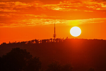 Orange color sunset above hill with transmitter tower in Zlin, Czechia.