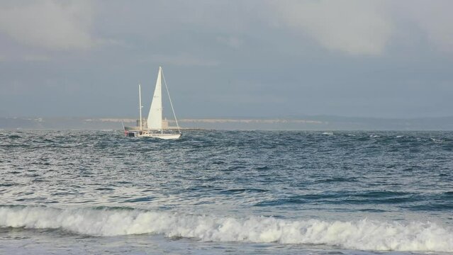 Lighthouse of Torre do Bugio with boat moving in front. Lisbon Guide Light. View from Howler Lighthouse