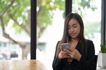 Obraz premium Business asian woman using smart phone at coffee shop..