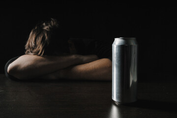 Man with jar of beer lying or sleeping on table at night. Alcohol addiction concept