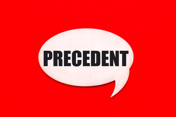 On a bright red background, a light wooden curly card with the text PRECEDENT