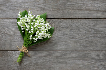  bouquet of white lilies of the valley on a wooden background, free space