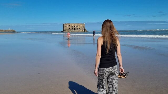 Elegant beautiful girl overlooking the bay in .Tarfaya,, Marroco 4K videos. walking along the sandy beach.