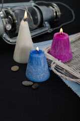 Three conic burning candles vertical view with empty background