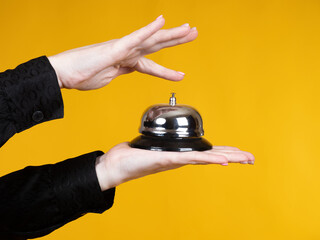 Call for reception desk bell in hands of woman. Concept calling service personnel. Girl calls...
