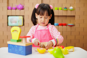 young girl pretend playing food preparing at home