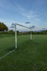 Rural soccer field in the light of the sunset, View of empty soccer goals, goals without nets, can be used as a background, background for graphic designers