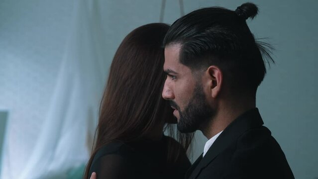 Dominant sexy dangerous bearded Cuban man whispering to his long-haired partner's ear. High quality 4k footage