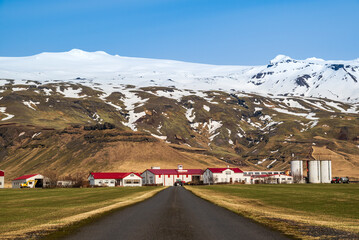 Road leading towards Thorvaldseyri farm, the famous farmstead located right in front of Eyjafjallajökull glacier and volcano with its snow-capped summit, Route 1 / Ring Road, Southern Region, Iceland © teddiviscious