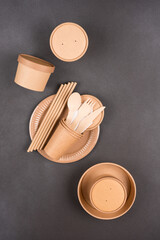 Vertical image of eco paper tableware and utensils - paper cups, containers, plates and wooden...