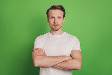 Confident masculine business man crossed hands look camera isolated on green color background