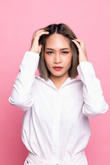 Portrait attractive asian woman feeling happy in front of a bright pink background.
