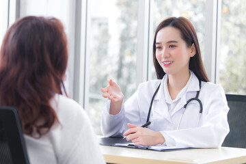 Asian professional  woman doctor suggests healthcare solution to her patient elderly in examination room at hospital.