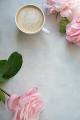 Abstract feminine mock up, cup of coffee and pink roses flowers on bright background. Wellbeing, relax, warm drinks. Copy space.