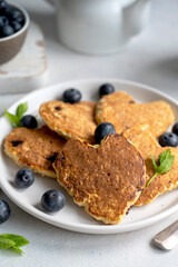 Pancakesheart shaped with fresh blueberries, Morning breakfast, delicious vegan pancakes.Bright background.