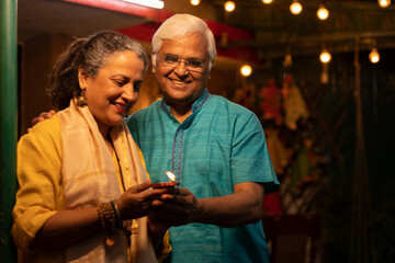 Indian family celebrating festival with Diya( oil lamp) in hand