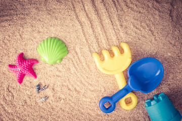 Fototapeta na wymiar beach toys to play in the sand, shovel, rake, starfish and shell on the sand on a sunny summer day