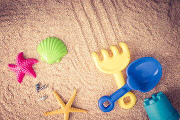 beach toys to play in the sand, shovel, rake, starfish and shell on the sand on a sunny summer day