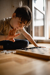 dad and his sons play checkers. A father spends time at home after work with his children. The...